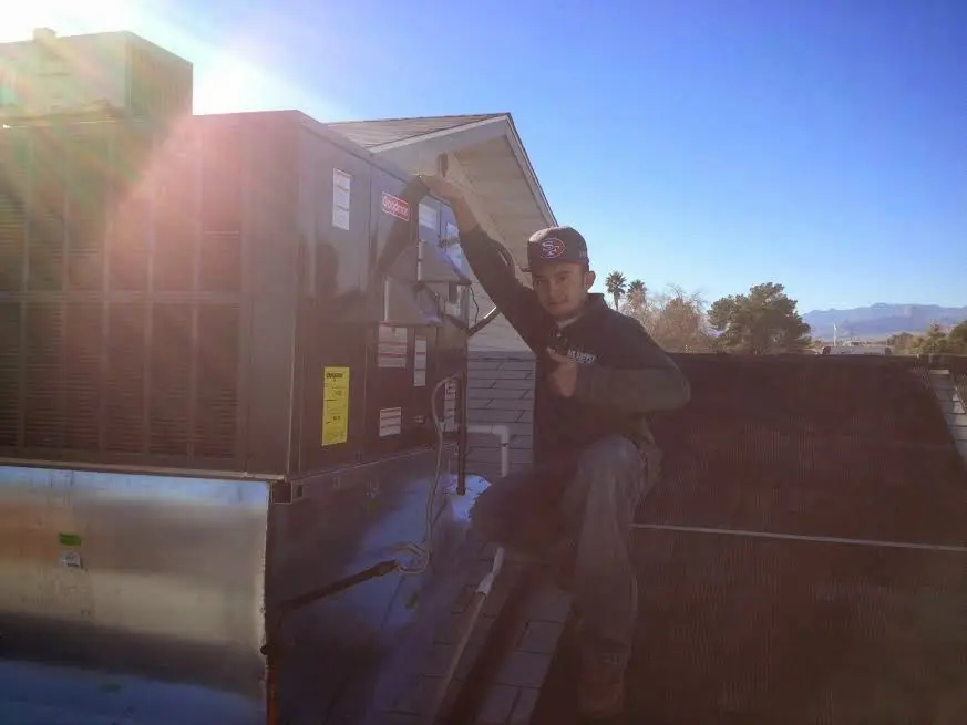 HVAC technician performing AC Tune-Up on a rooftop unit in Clearfield